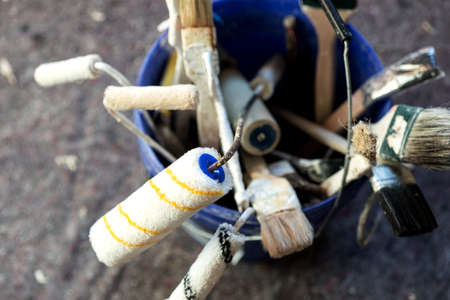 Different paint brushes and paint roller in the blue bucket. Painter equipmentの写真素材