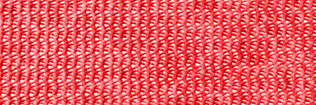Red plastic background with holes. Panoramic red pattern