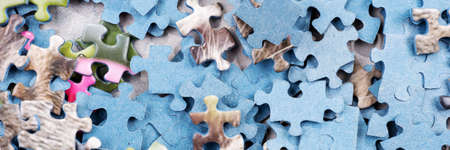 Panoramic image of jigsaw puzzle pieces. Many pieces of an unfinished puzzleの写真素材