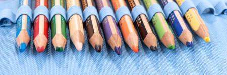 Row of pencils. Colored pencils on a blue background. panoramaの写真素材