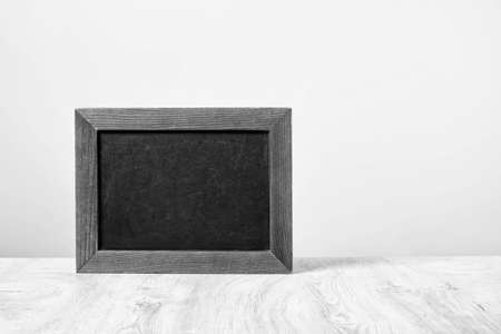 Empty black chalkboard isolated in front of a white wall