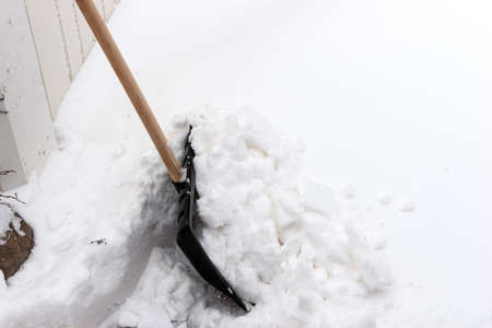 Snow shovel to clear the snow in the front of the garage doorの写真素材