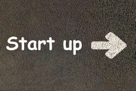 Start Up, word on the asphalt road with right arrow. Launching a new project or business