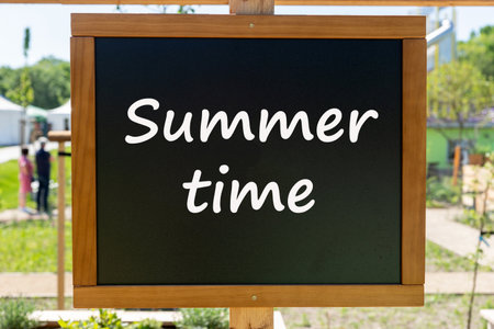 Black chalkboard with the inscription Summertime in the gardenの写真素材