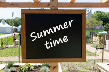 Black chalkboard with the inscription Summertime in the gardenの写真素材