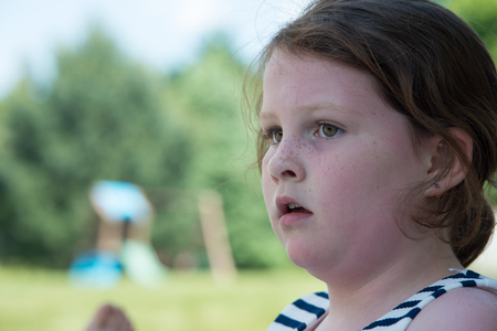 Close Portrait of Young Girl Looking Concerned Outsideの写真素材