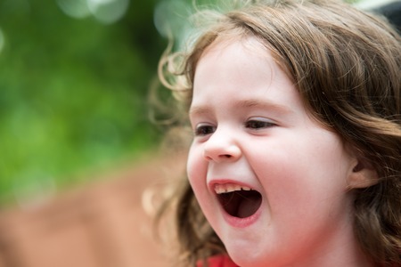 Happy Young Girl on Amusement Ride with Hair Blowing in Windの写真素材