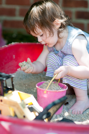 Adorable little girl playing in a sandboxの写真素材