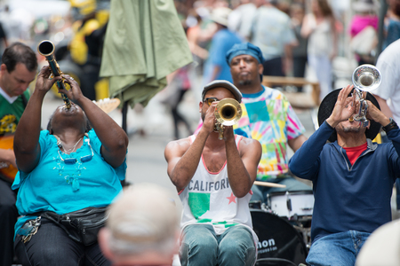 NEW ORLEANS - APRIL 13: In New Orleans, a jazz band plays jazz melodies in the street for donations from the tourists and locals passing by on April 13, 2014のeditorial素材