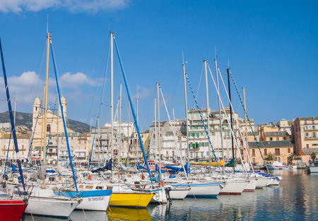 Bastia, Corsica, France March 4 2012: colorful port of Bastia with boats, buildings and church view is a popular tourist site.のeditorial素材