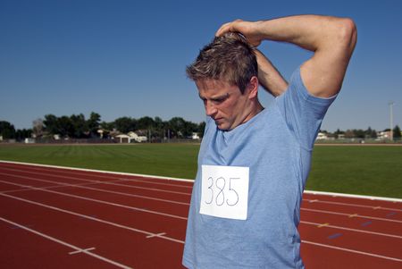 Male athlete stretches before raceの写真素材