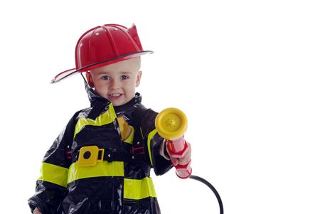Little boy fire fighter points water sprayer at cameraの写真素材