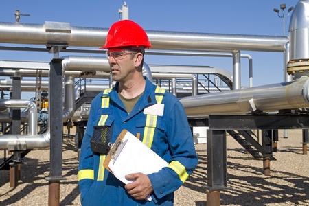 Male in full safety work gear inspects compressor site as daily dutiesの写真素材