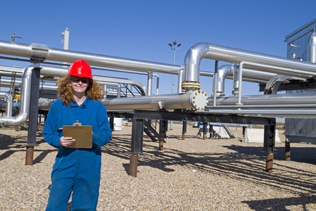 female gas field operator in full safety gear completes daily dutiesの写真素材