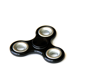 Black color fidget spinner isolated on whiteの写真素材