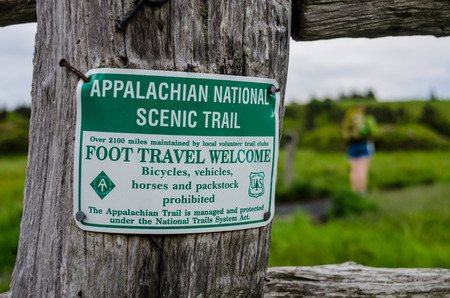 A white and green sign nailed to a fence post labels the famous Appalachian Trailの写真素材
