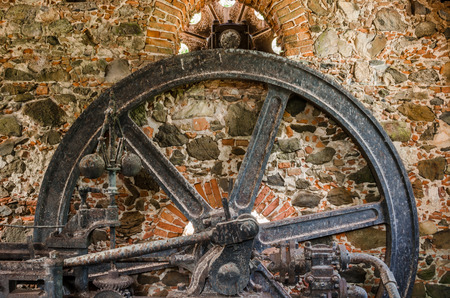 An iron wheel hangs on the ruins of an old sugar plantation in the Caribbean
