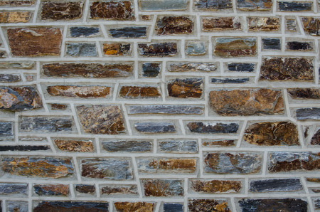 Wide view of an aged brick wall with bricks of varying shapes and sizes
