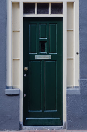 A forest green door against a cornflower blue wallのeditorial素材