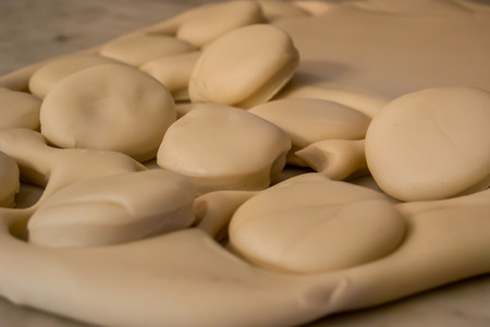 Small biscuits are cut out of dough that has been rolled repeatedly to make an old fashioned southern delicacyの写真素材