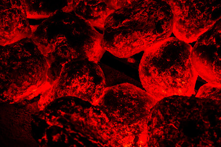 A close view of hot coals underneath a grill