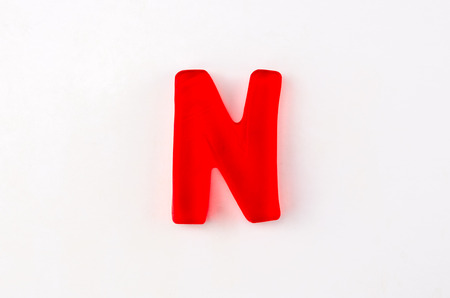 A red gummy letter in the shape of N isolated on whiteの写真素材