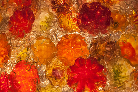 A background image of red, orange, and clear blown glass