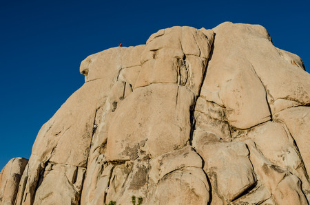 Rock climbers on large boulder during a sunny winter dayの写真素材