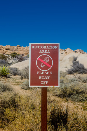 Restoration area sign vertical reminds visitors not to disturb the fragile terrainの写真素材