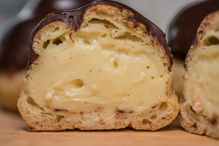 Pastry cream in sliced cream puff with chocolate ganache covering