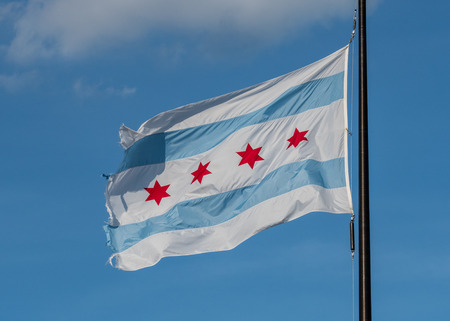 Weathered Chicago Flag Waving against blue sky