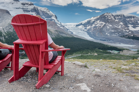 Behind View of Woman Sitting In Chair Enjoying the View in the Canadian Rockiesの写真素材