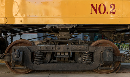 Section of Train Wheels underneath yellow car