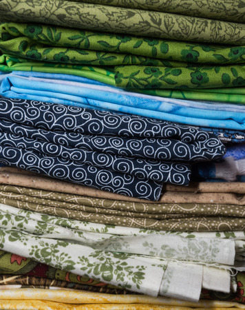 Stack of Folded Fabrics with blue spiral  pattern in the middle