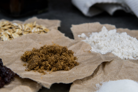 Brown Sugar and Other Small Amounts of Ingredients on torn brown paperの写真素材