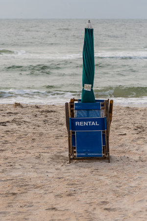 Folded Rental Beach Chair and Umbrella along coastのeditorial素材