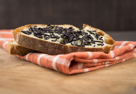 Low Angle of Chocolate Sprinkles on Bread over orange plaid napkinの写真素材