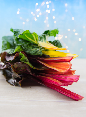 Stack of Rainbow Chard Leaves on light wooden table topの写真素材