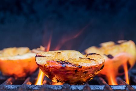 Grilled Peaches and Flames caramelize during a summer cookoutの写真素材
