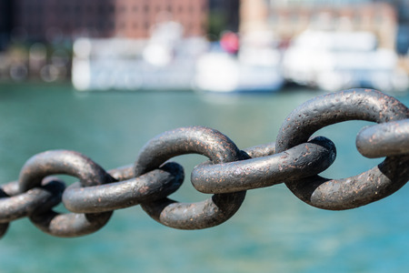 Five Links in Iron Chain hanging in front of waterの写真素材