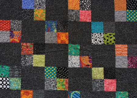 Black and White Quilt with Squares of Color Scattered Throughoutの写真素材