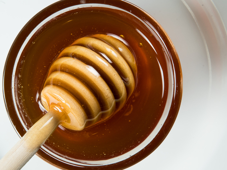 Honey Dipper Floats Atop Honey in glass bowl