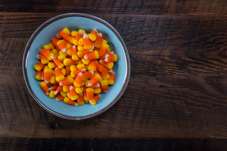 Blue Bowl of Candy Corn with Copy Space over wooden tableの写真素材