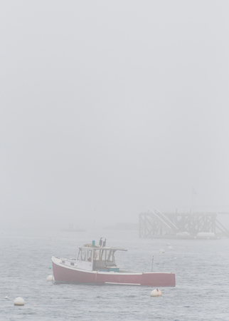 Lobster Boat Anchored in Foggy Bay along Atlantic coastの写真素材