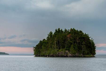 Single Island Covered in Thick Woods just before sunset