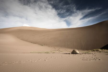 Tent Sits Below Sand Dune Wall in wilderness area