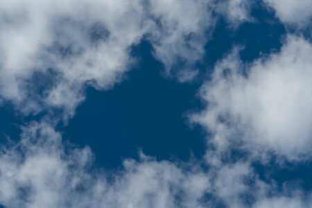 Clouds with Hole to Blue Sky background image