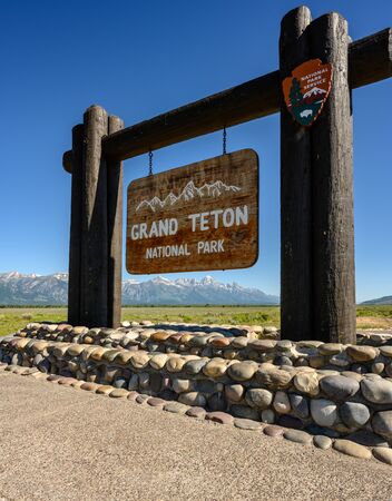Jackson Hole, United States: July 21, 2019: Mountains Visible Through Grand Teton Sign at park entranceの写真素材