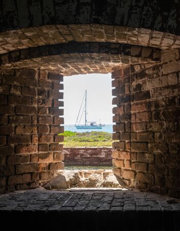 Framed Sailboat Moored in Dry Tortugas  through brick windowの写真素材