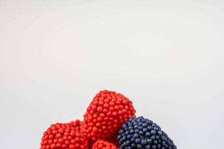 Close up of sprinkles on fruit gummies on white